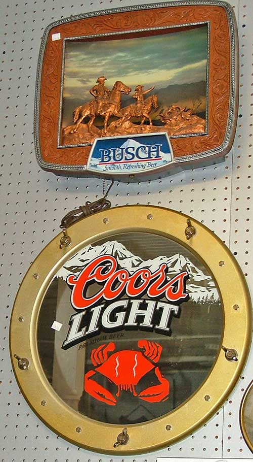 two advertising signs include top - Busch beer with two people on horseback on a mountain top and bottom - Coors Light porthole with crab 