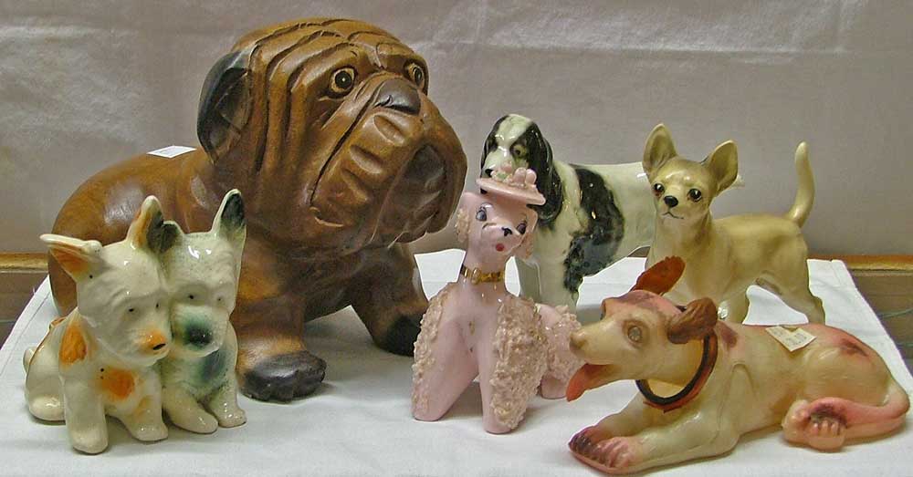 Dog figurines include a wooden dog, Sprainger Spaniel porcellain, Scottie Dog Planter, pink spaghetti Poodle, a Chihuahua and a plaster nodder dog all at Bahoukas in Havre de Grace