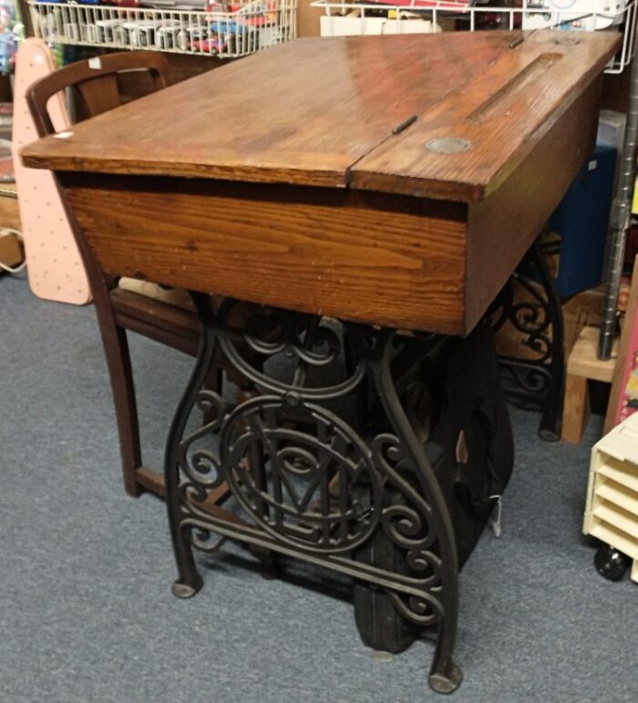 Wooden school desk, cast iron base, lid lifts to a cubby for storing paper and books