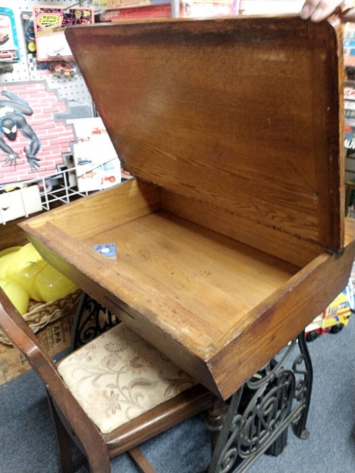 wood school desk with cast iron base, lid lifts up for a cubby that can hold books and papers