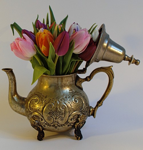 beautiful tiny flowers arrangement in a small silver teapot