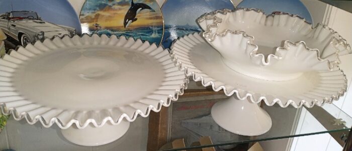 2 cake pedestal cake platters and a serving bowl of white milk glass with silver edging