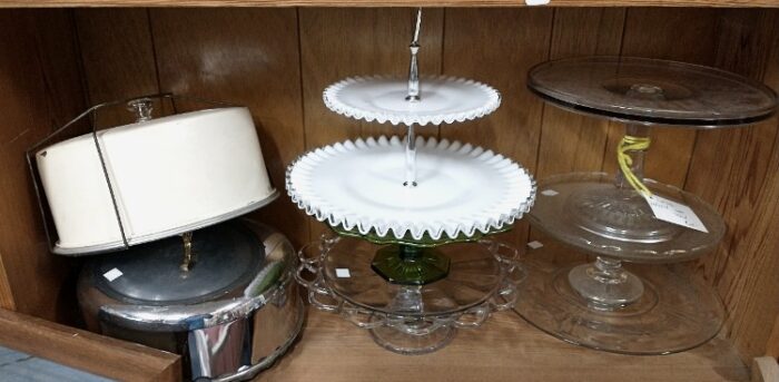 selection of covered cake carriers and cake platters on pedestals